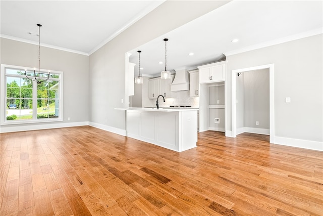 kitchen featuring light wood-style flooring, white cabinetry, light countertops, and crown molding