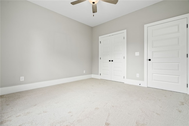 unfurnished bedroom featuring a closet, carpet flooring, a ceiling fan, and baseboards