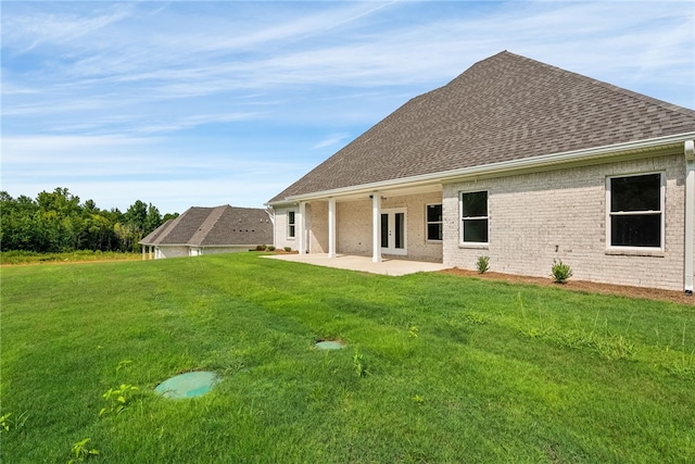 rear view of property with a patio area, roof with shingles, a yard, and french doors