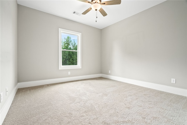 carpeted empty room with baseboards, visible vents, and a ceiling fan