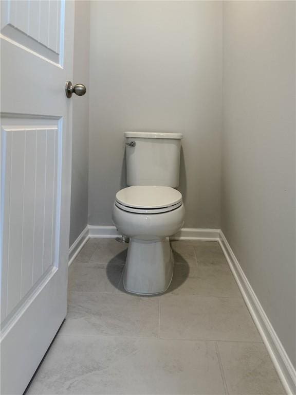 bathroom featuring tile patterned flooring, toilet, and baseboards