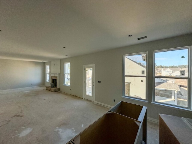 unfurnished living room featuring plenty of natural light and concrete flooring