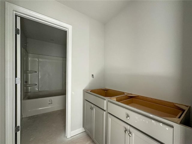 bathroom with concrete floors, bathing tub / shower combination, and vanity