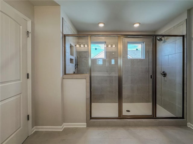 bathroom featuring a shower stall and baseboards