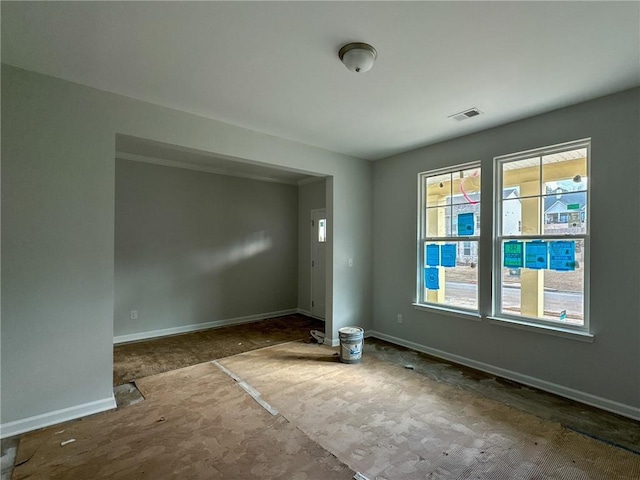 spare room featuring baseboards and visible vents