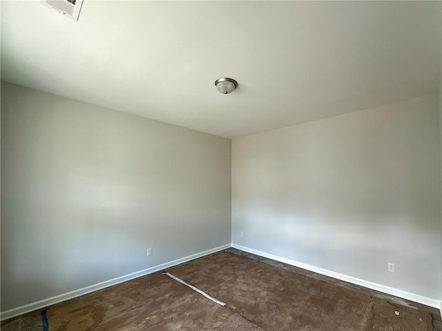 unfurnished room with baseboards and concrete flooring