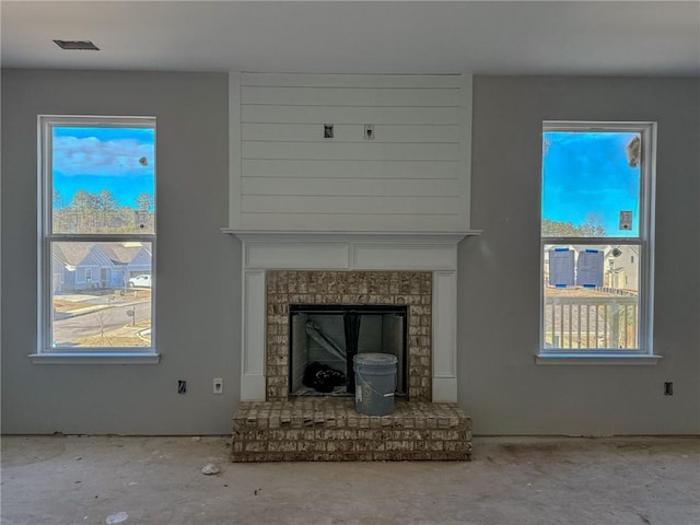 unfurnished living room with a healthy amount of sunlight and a fireplace