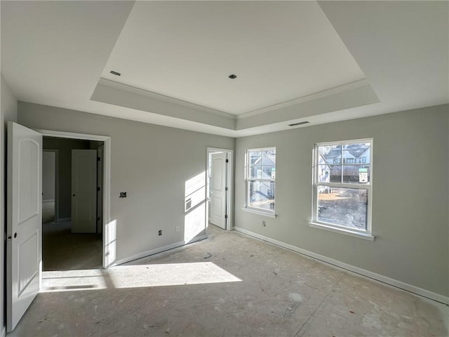 spare room featuring a tray ceiling and ornamental molding