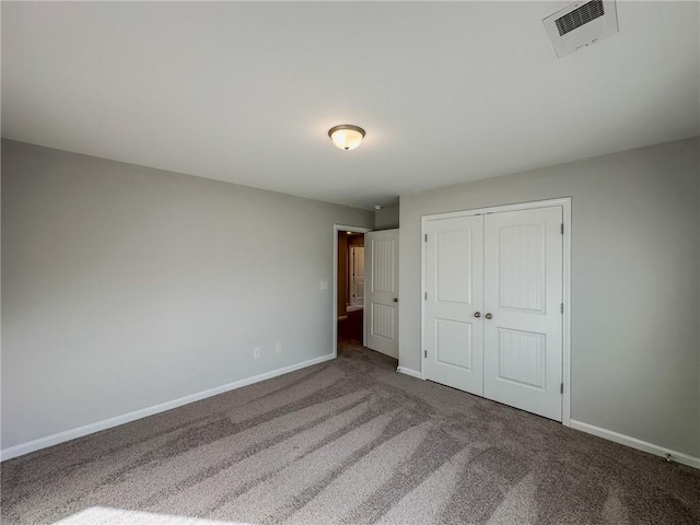 unfurnished bedroom featuring visible vents, baseboards, a closet, and carpet flooring