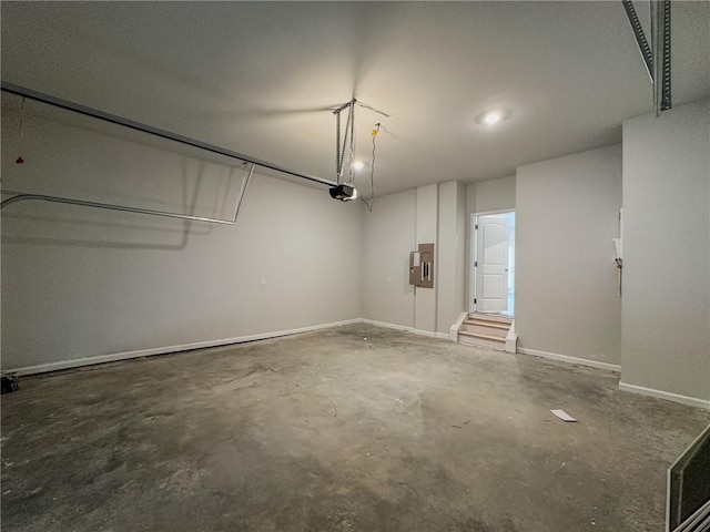 garage featuring electric panel, a garage door opener, and baseboards