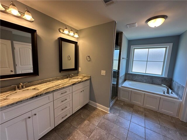 1882 Waterfall Rd, Auburn, AL 36832 - bathroom featuring baseboards, double vanity, a bath, and a shower stall