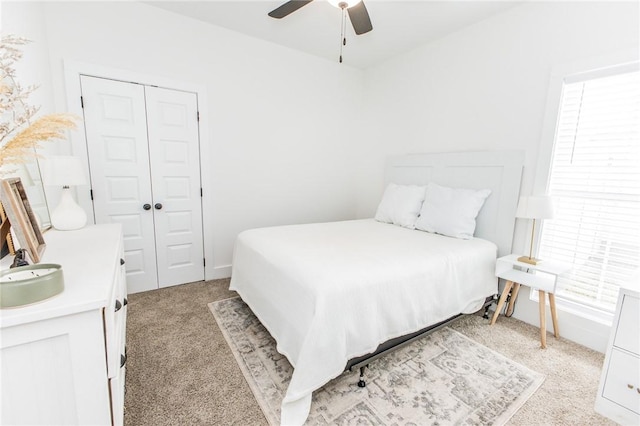 bedroom with light carpet, a closet, and ceiling fan