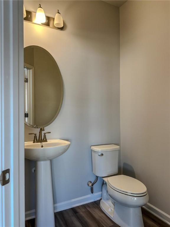 bathroom featuring toilet, hardwood / wood-style flooring, and sink