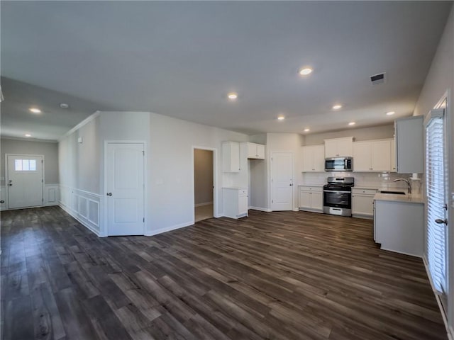 kitchen with stainless steel appliances, dark hardwood / wood-style flooring, crown molding, white cabinets, and sink