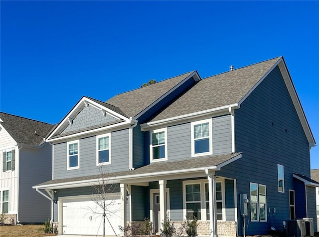 craftsman-style house featuring central AC unit, covered porch, and a garage