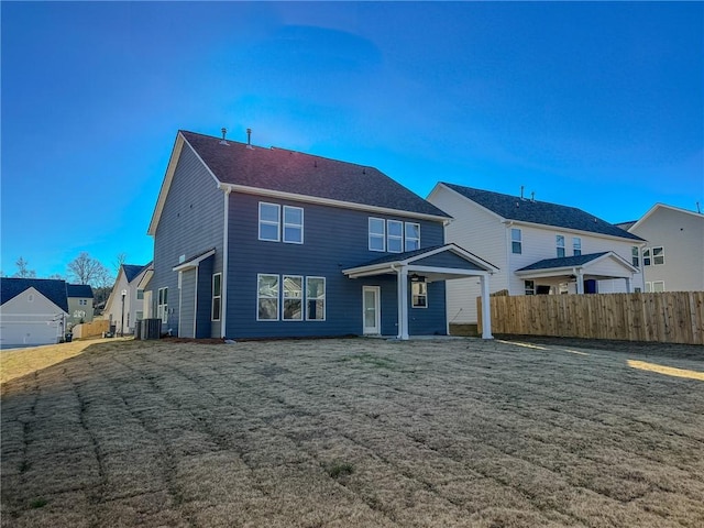 back of property with cooling unit and a lawn