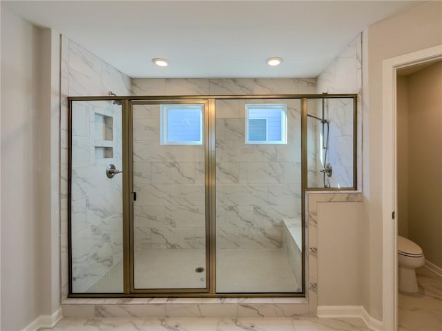 bathroom with a shower with shower door and toilet