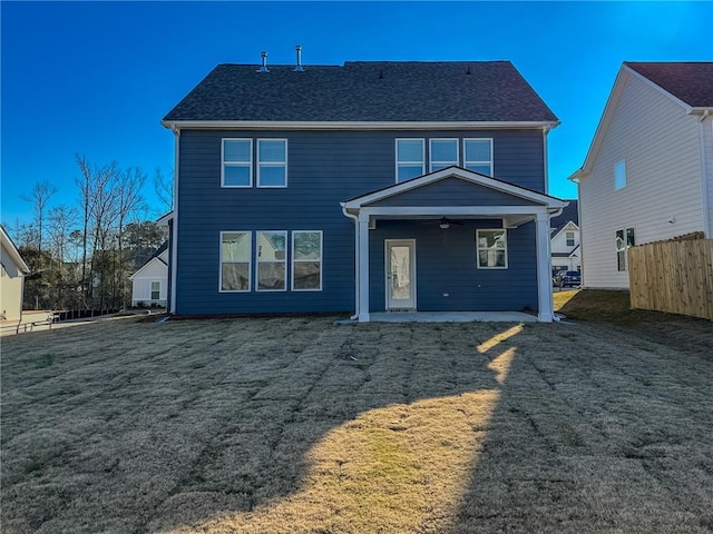 rear view of property featuring ceiling fan, a lawn, and a patio