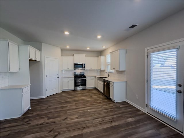 kitchen featuring backsplash, appliances with stainless steel finishes, sink, and white cabinetry