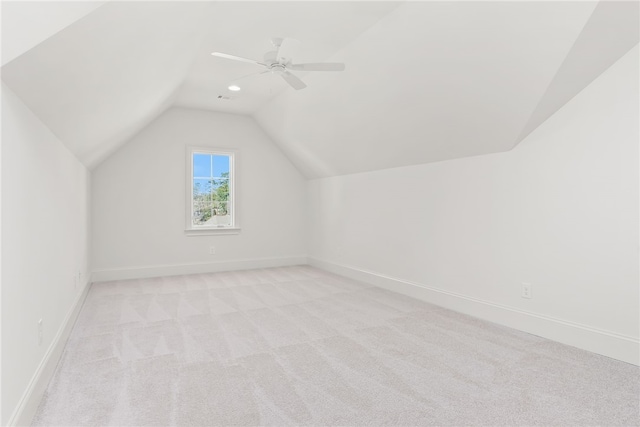 additional living space featuring light carpet, vaulted ceiling, and ceiling fan