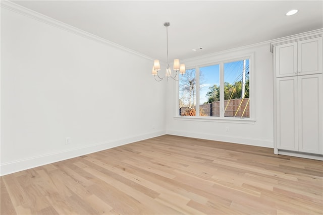 unfurnished dining area featuring crown molding, light wood-type flooring, and a notable chandelier