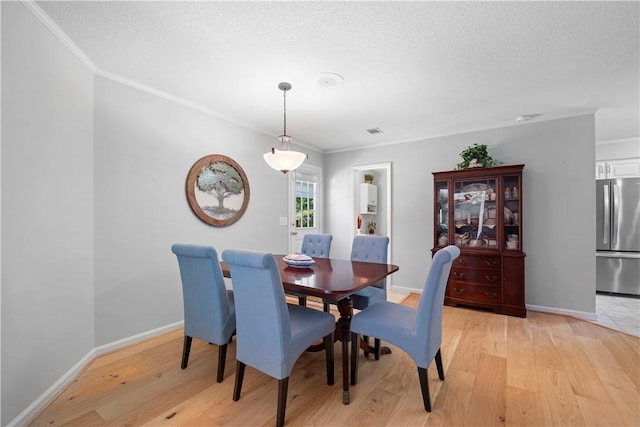 1340 Ferndale Dr, Auburn, AL 36830 - dining room featuring crown molding, light wood-style flooring, and a textured ceiling