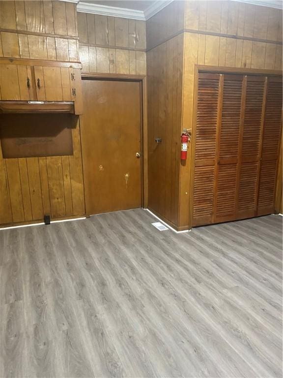 interior space featuring light hardwood / wood-style floors and crown molding