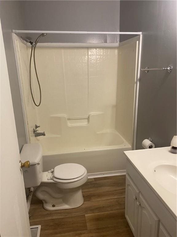 full bathroom featuring vanity,  shower combination, hardwood / wood-style flooring, and toilet