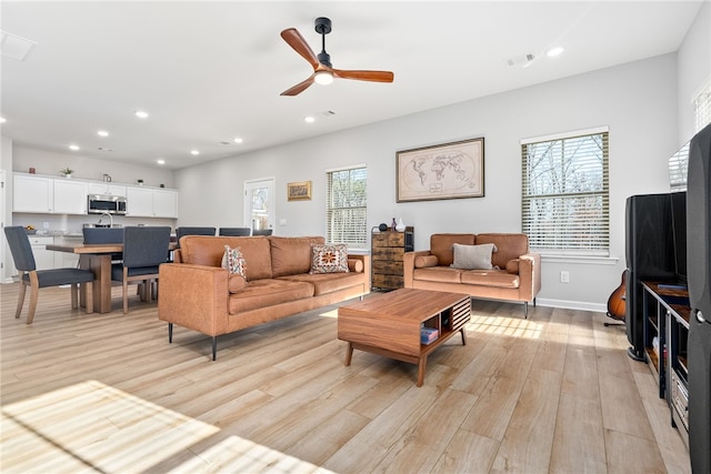 living room featuring light wood finished floors, visible vents, baseboards, recessed lighting, and a ceiling fan