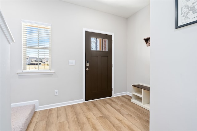 foyer featuring baseboards and wood finished floors