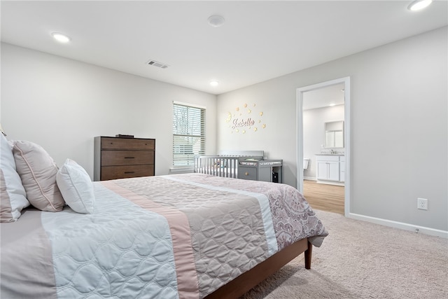 bedroom with visible vents, recessed lighting, connected bathroom, baseboards, and light colored carpet