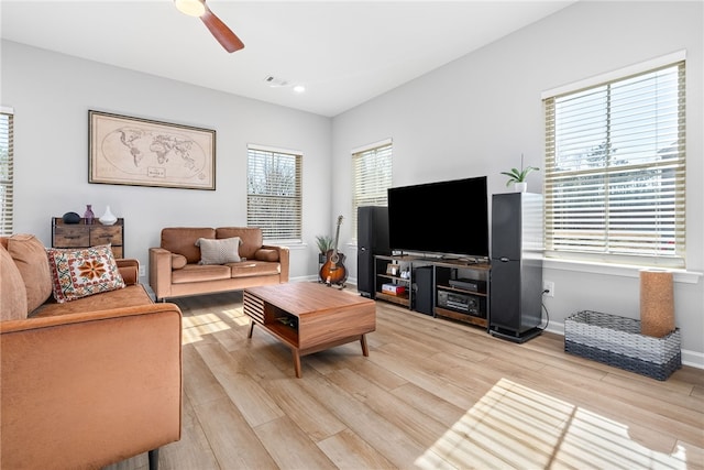 living area featuring a ceiling fan, light wood-style floors, and baseboards