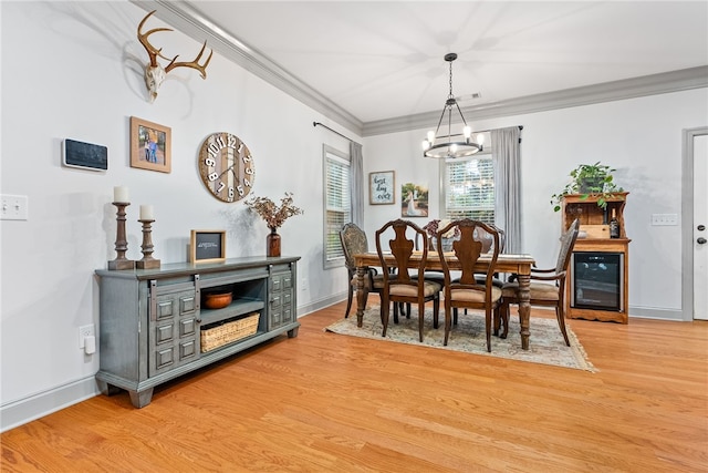 dining area with wine cooler, light hardwood / wood-style floors, a notable chandelier, and ornamental molding