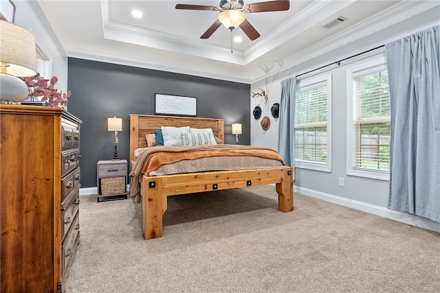 carpeted bedroom featuring a tray ceiling, ceiling fan, and crown molding