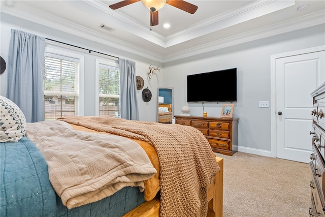 carpeted bedroom with ceiling fan, ornamental molding, and a tray ceiling