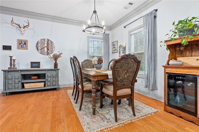 dining area featuring an inviting chandelier, wood-type flooring, and ornamental molding