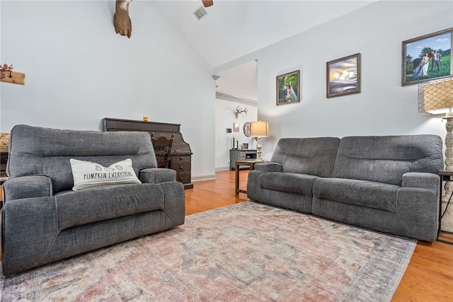 living room featuring hardwood / wood-style flooring, vaulted ceiling, and ceiling fan