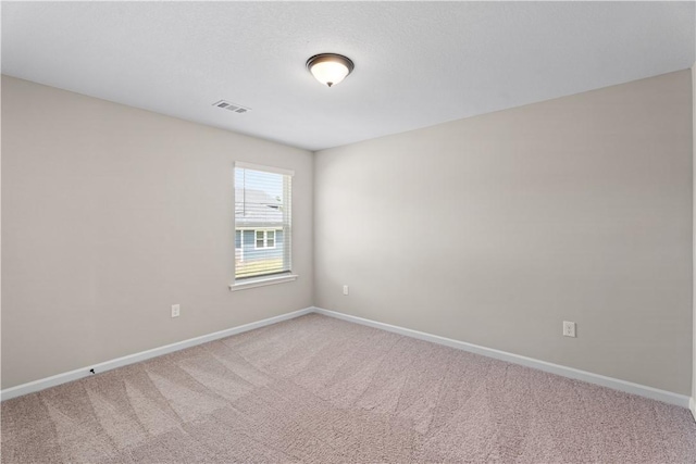 carpeted empty room with visible vents and baseboards