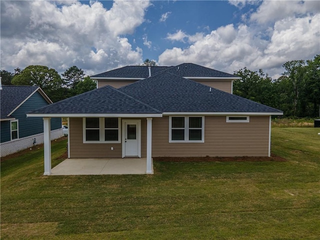 back of house featuring roof with shingles, a patio, and a lawn