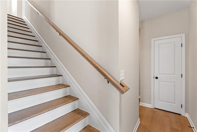 stairway with baseboards and wood finished floors