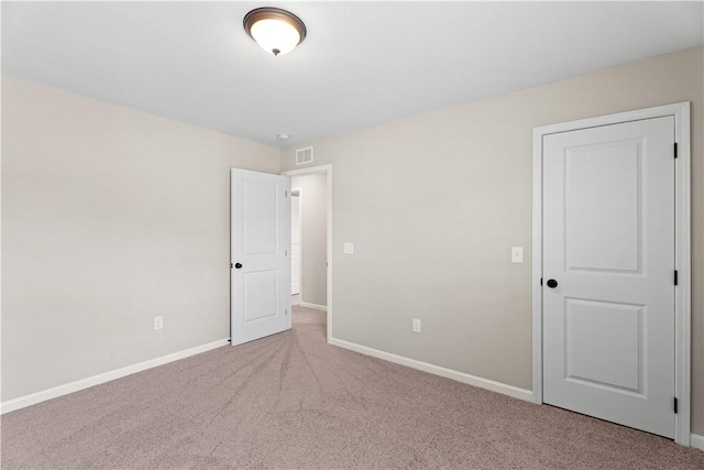 carpeted spare room featuring baseboards and visible vents