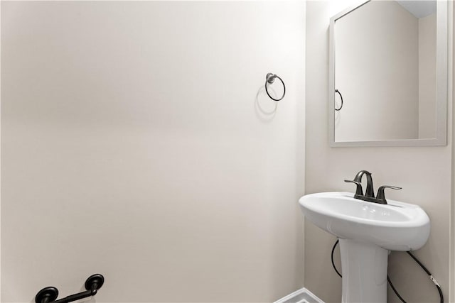 bathroom with a sink and baseboards