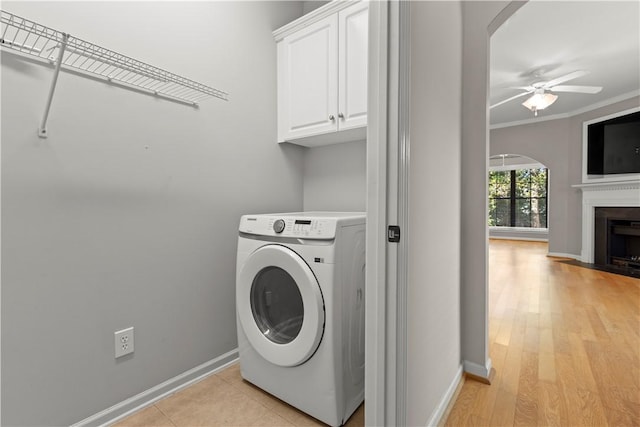 laundry area featuring cabinets, washer / clothes dryer, ceiling fan, and crown molding