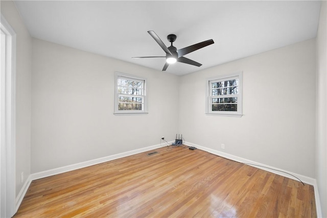 unfurnished room with light wood-type flooring, baseboards, visible vents, and ceiling fan