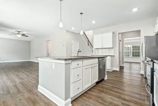 kitchen with stainless steel appliances, dark wood-style flooring, a sink, and white cabinets