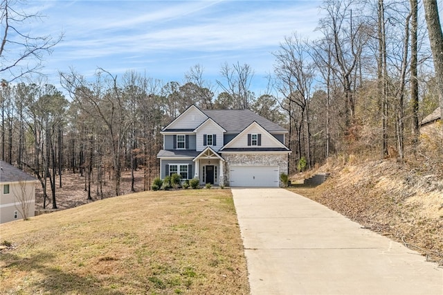 traditional home featuring an attached garage, concrete driveway, stone siding, and a front yard