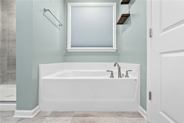 full bath featuring a garden tub, baseboards, and a stall shower