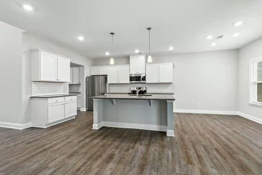 kitchen with dark countertops, white cabinetry, appliances with stainless steel finishes, and decorative backsplash