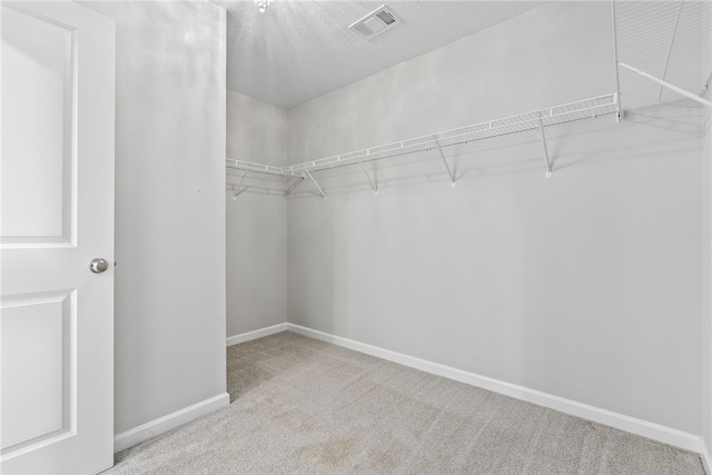 walk in closet featuring carpet flooring and visible vents