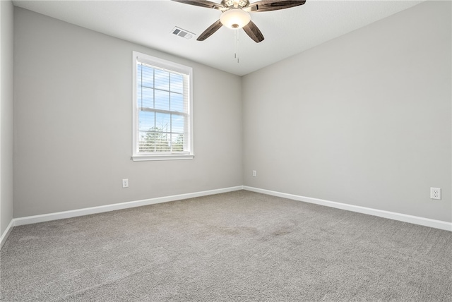 empty room with carpet, visible vents, ceiling fan, and baseboards